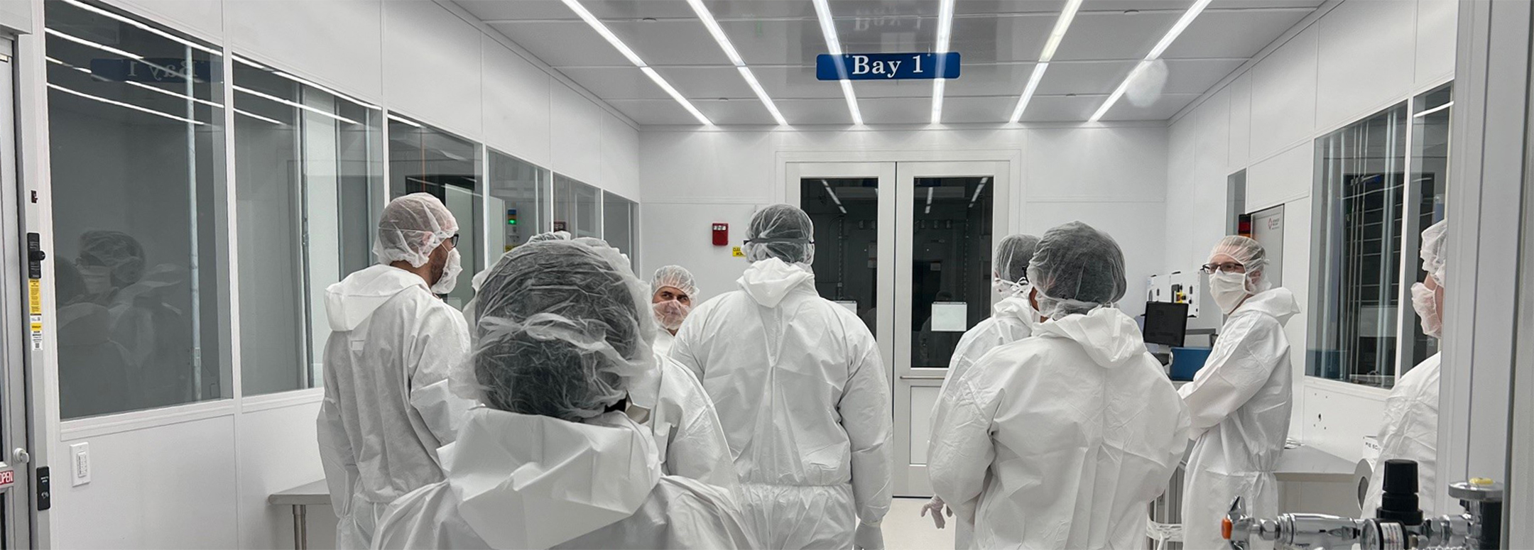 a group of students in cleanroom gowning attire with instructor